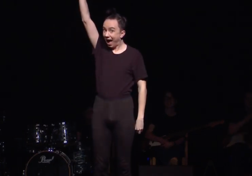 bilde av ung gutt på scene i sorte klær