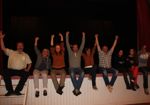 Mennesker sittende på en scene med armer i været