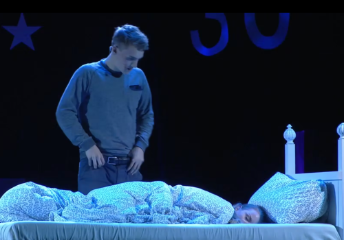 en ung mann som står ved senga til en som sover