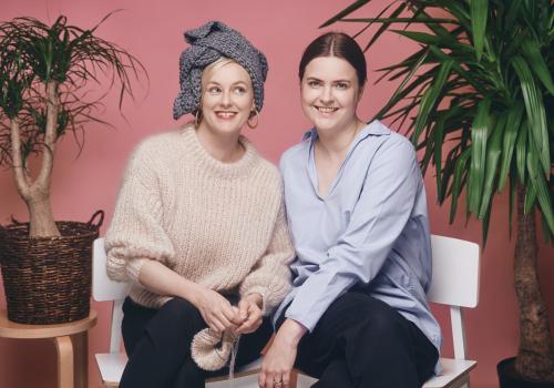 to kvinner på en benk og de har strikketøy