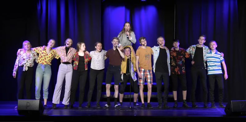 Mange mennesker på rekke på en scene